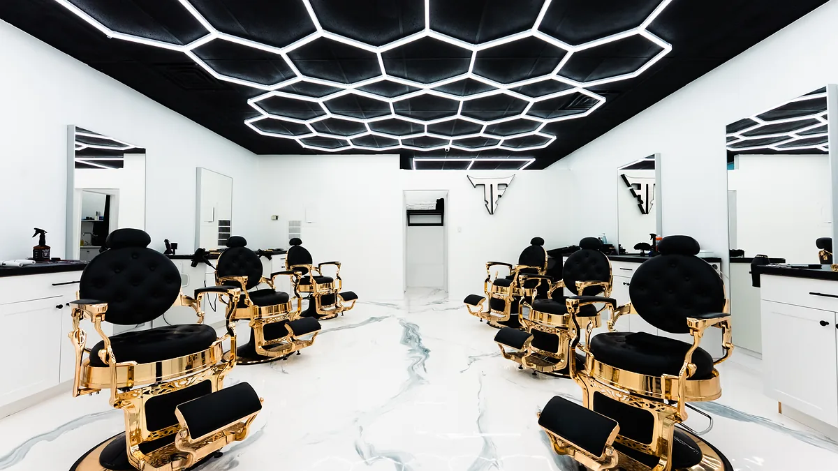 Inside Toronto Fades: black and gold barber chairs under a hexagon light ceiling